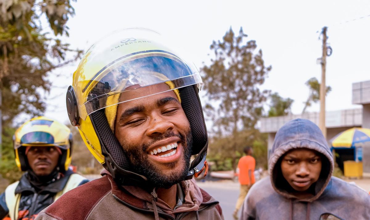 Un chauffeur de moto-taxi souriant, casque jaune
